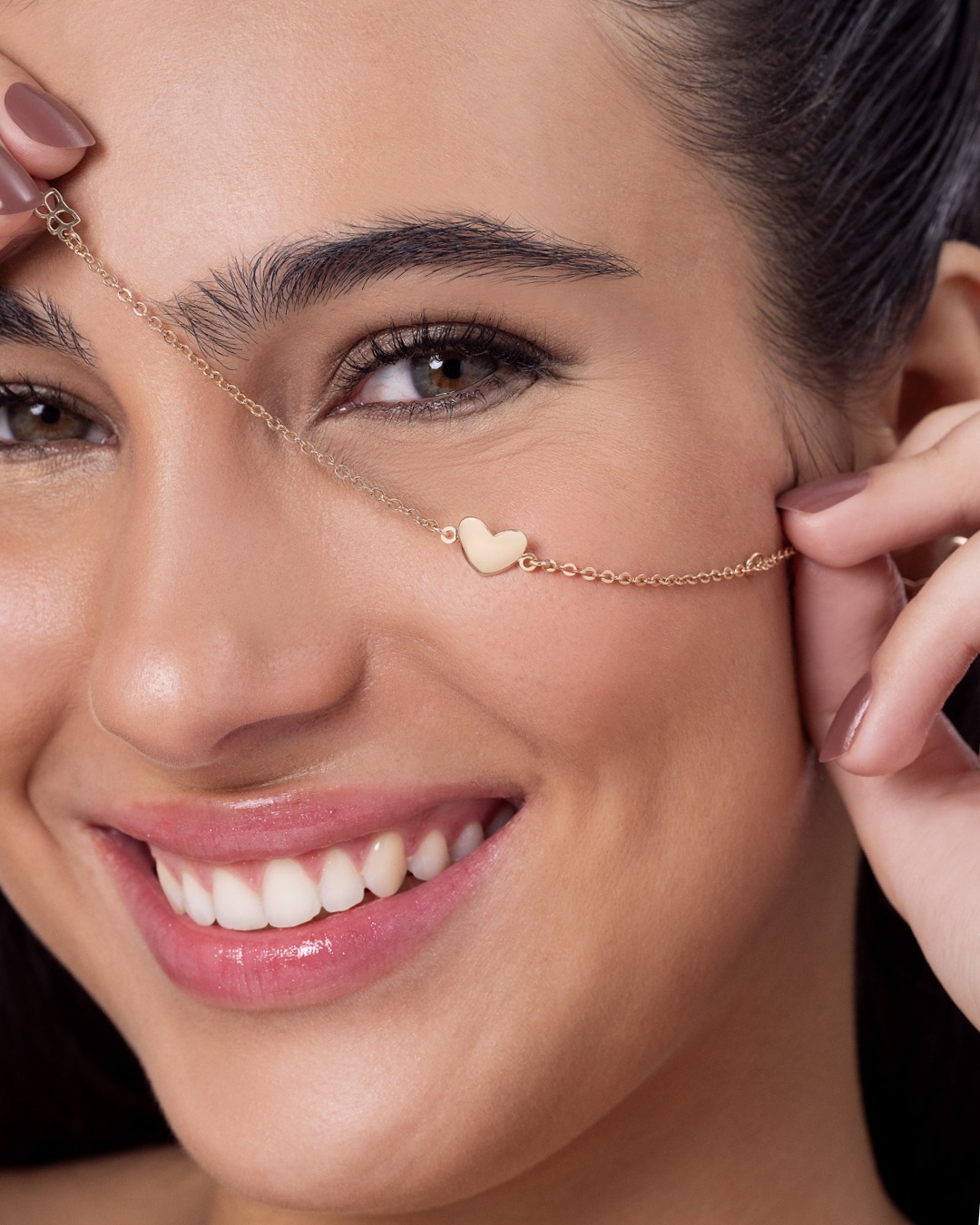 Modelo usando pulseira delicada com pingente coração